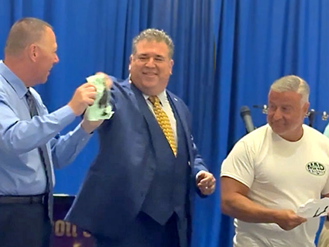 Scott performing with a couple of audience members at a business luncheon.